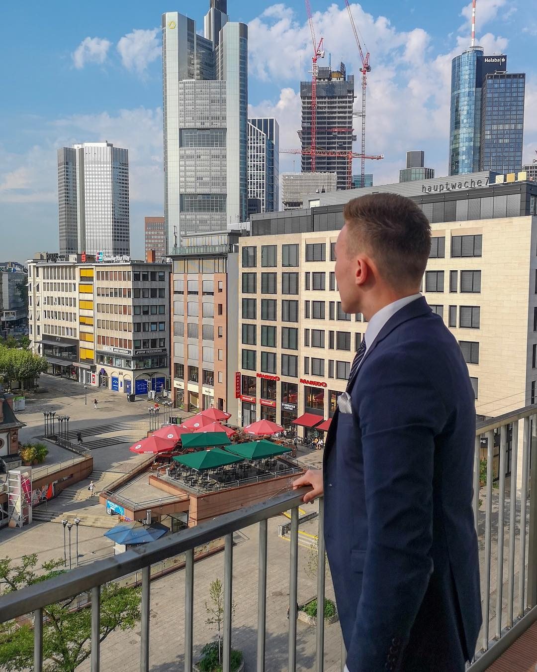 Arthur in a suit in front of the Frankfurt skyline