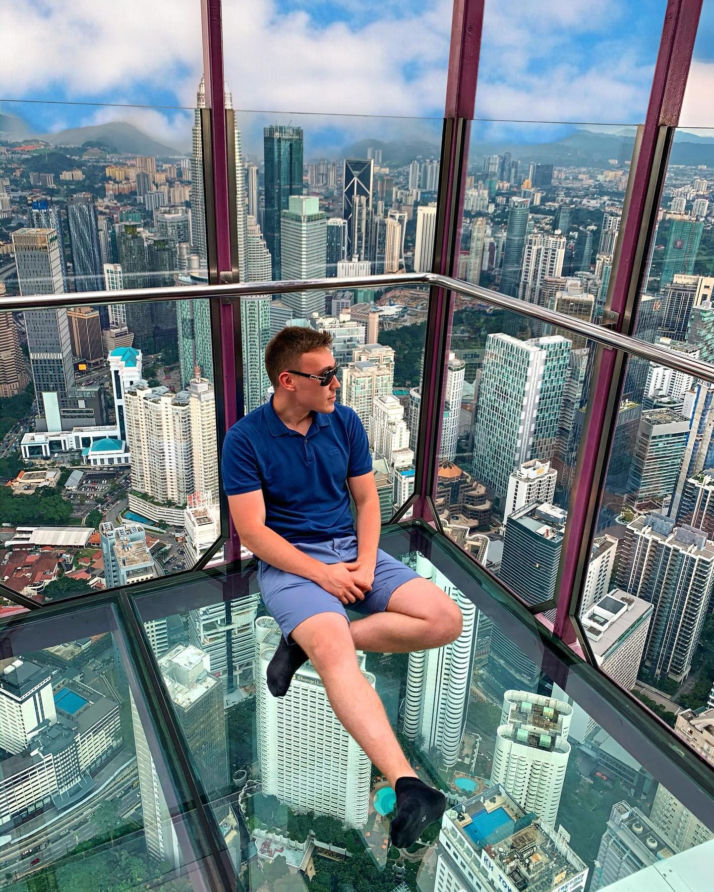 Arthur sitting in a glass skydeck high above Kuala Lumpur